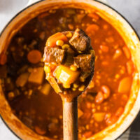 wooden spoon scooping a portion of the soup out of the pot