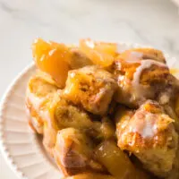 zoomed in image of cinnamon roll casserole with apples on plate.