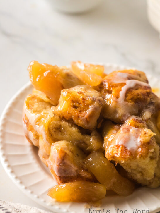 zoomed in image of cinnamon roll casserole with apples on plate.
