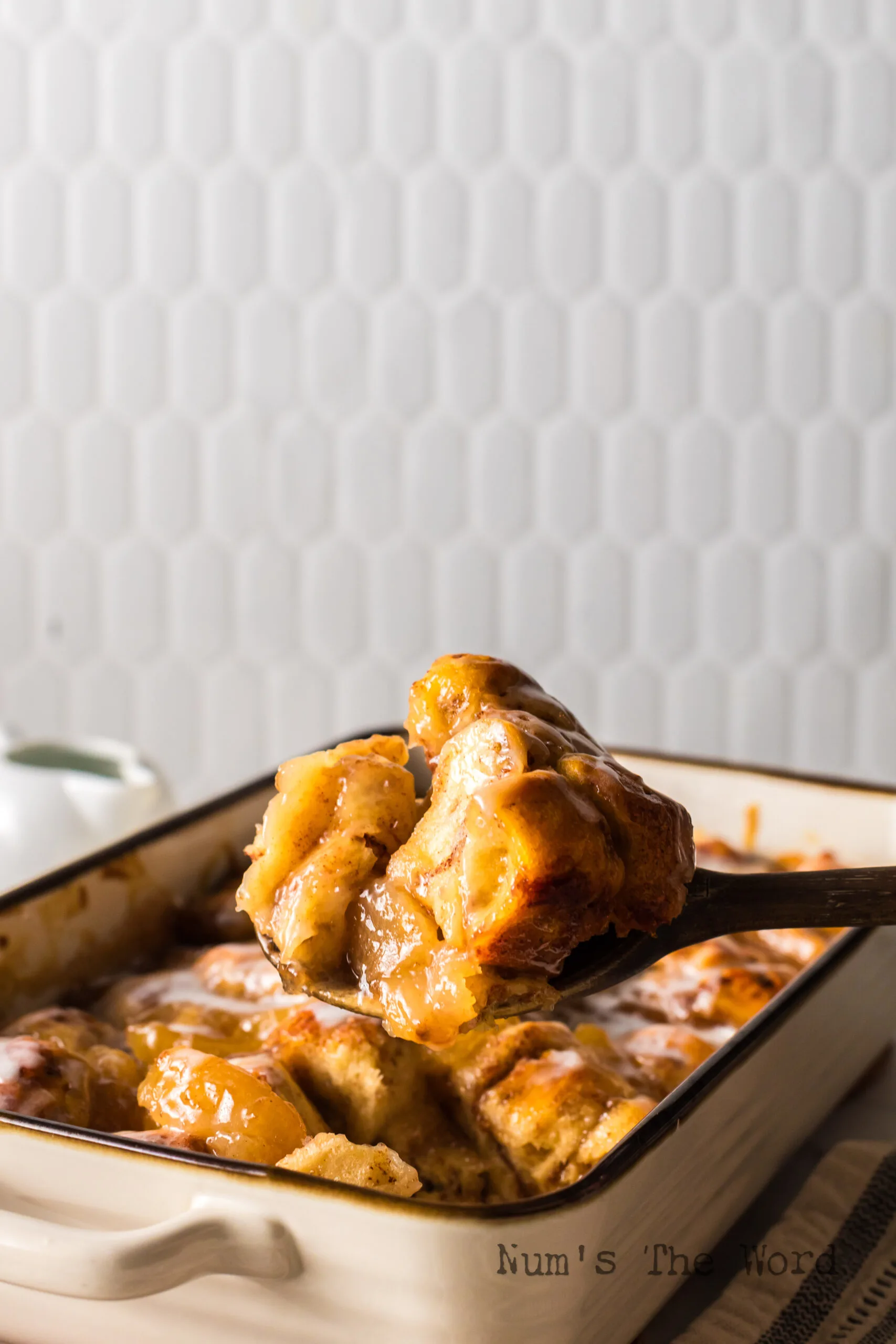wooden spoon scooping some breakfast casserole out of the pan.