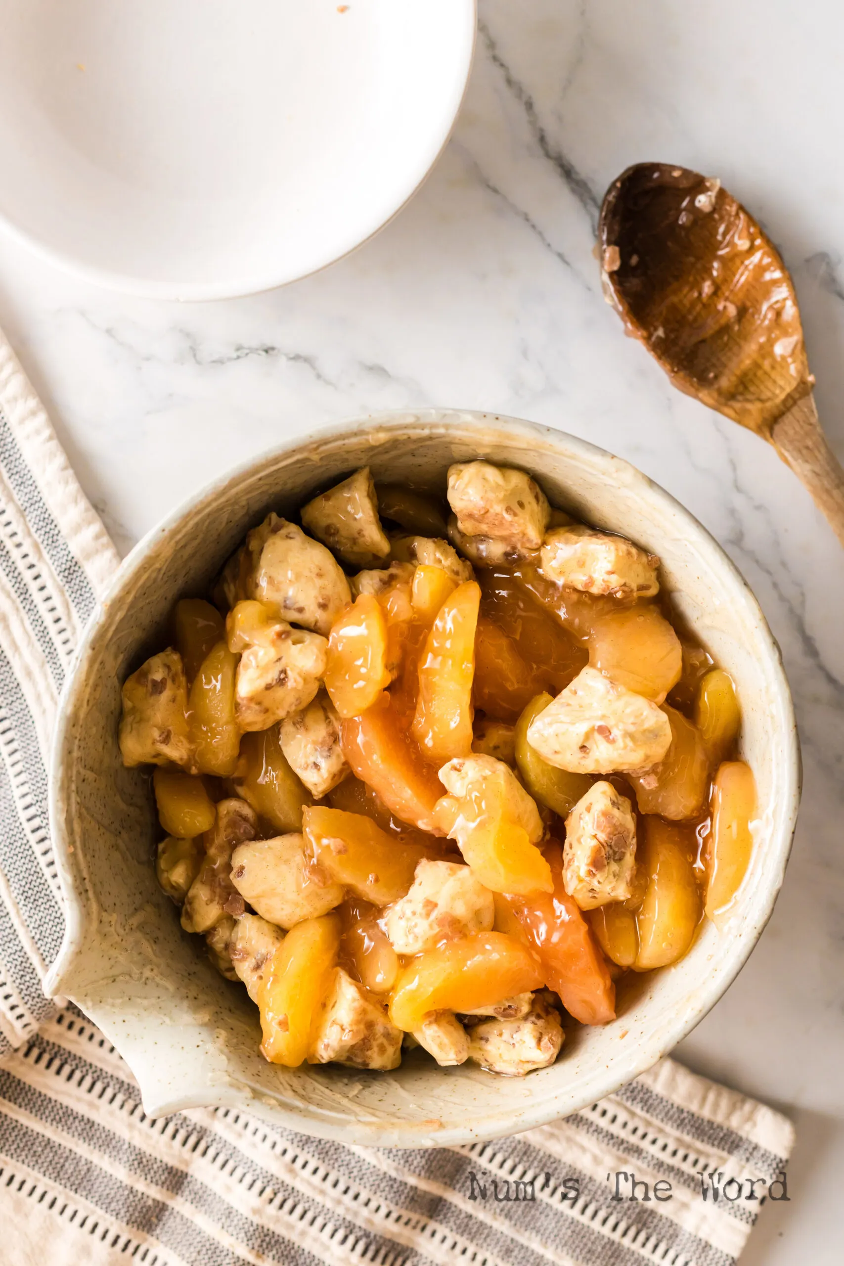 cut up cinnamon rolls and apple pie filling mixed in a bowl