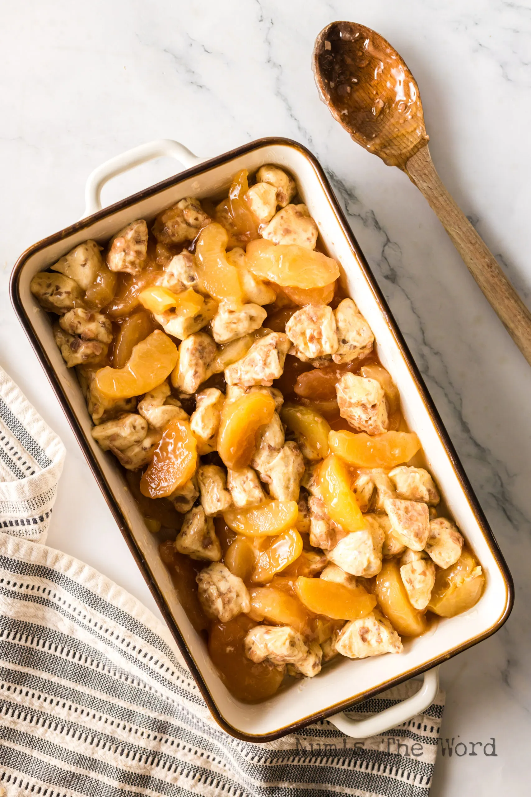 apple pie filling and cinnamon rolls in a casserole pan.