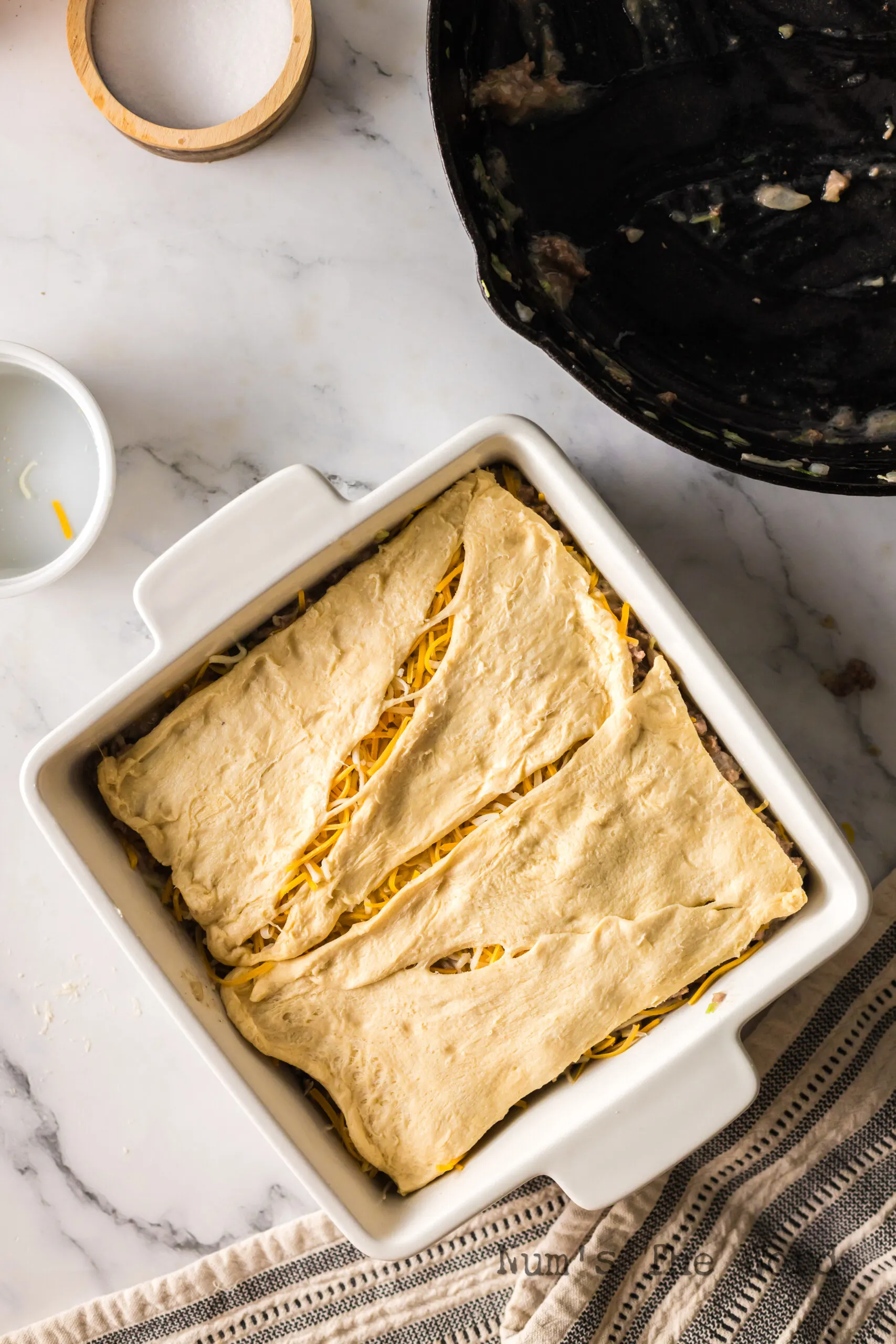 top layer of crescent rolls in pan over cheese.