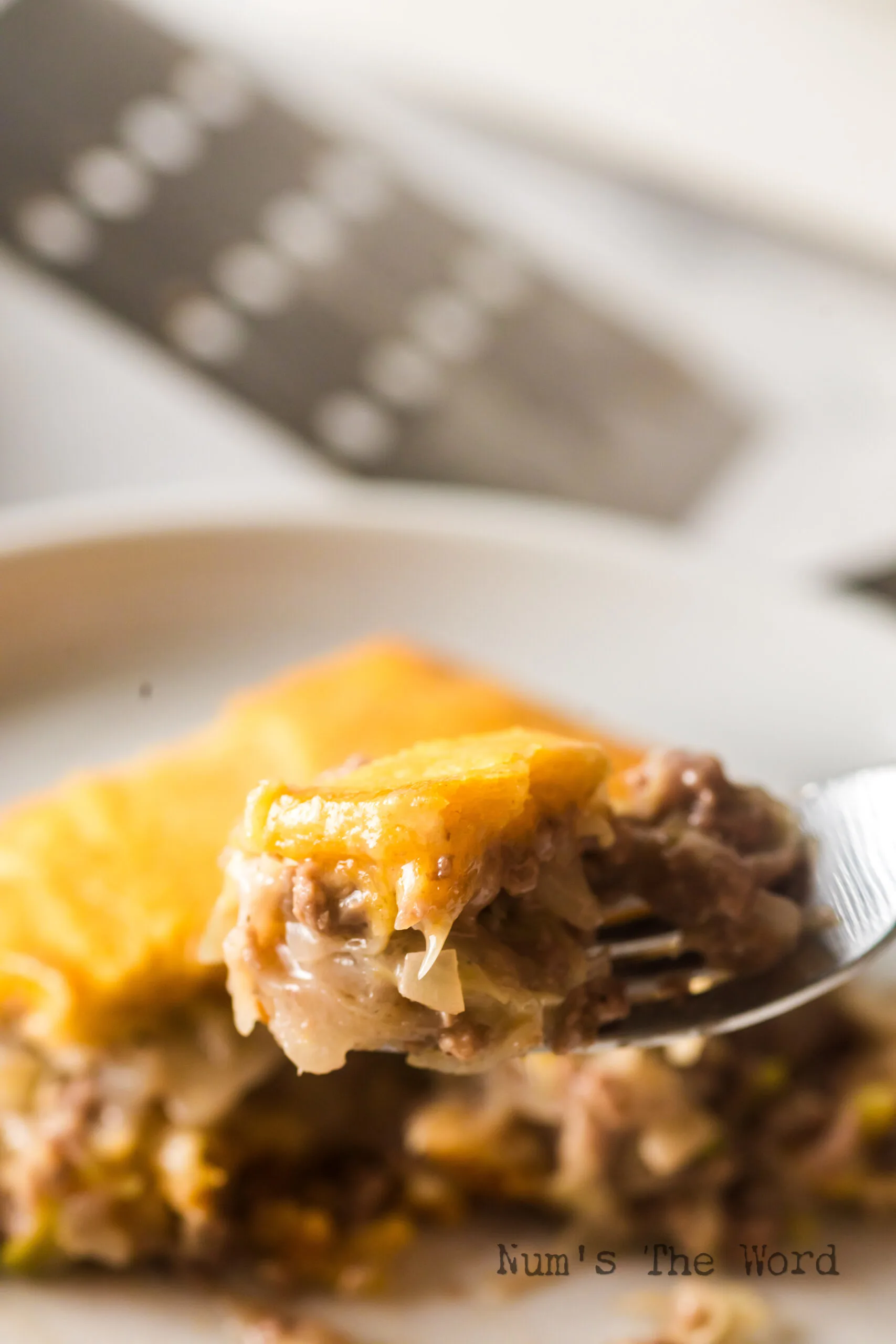 casserole on plate with a fork holding a piece up.