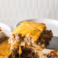 A slice of casserole being removed from pan.