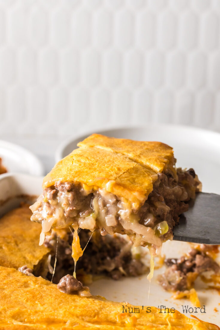 A slice of casserole being removed from pan.