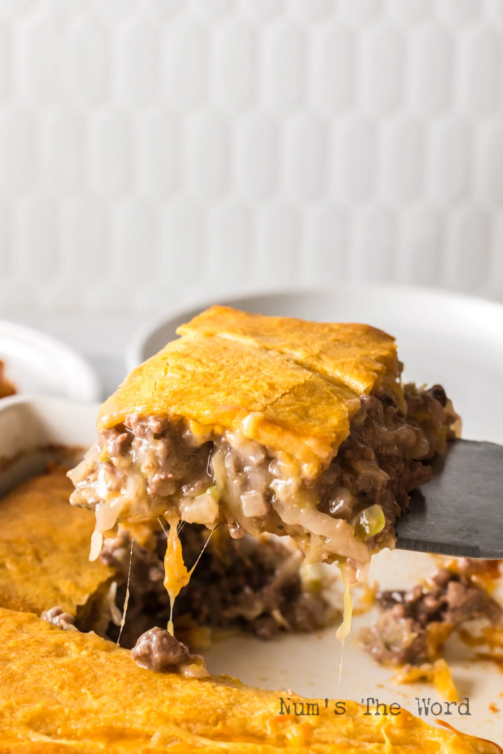 A slice of casserole being removed from pan.