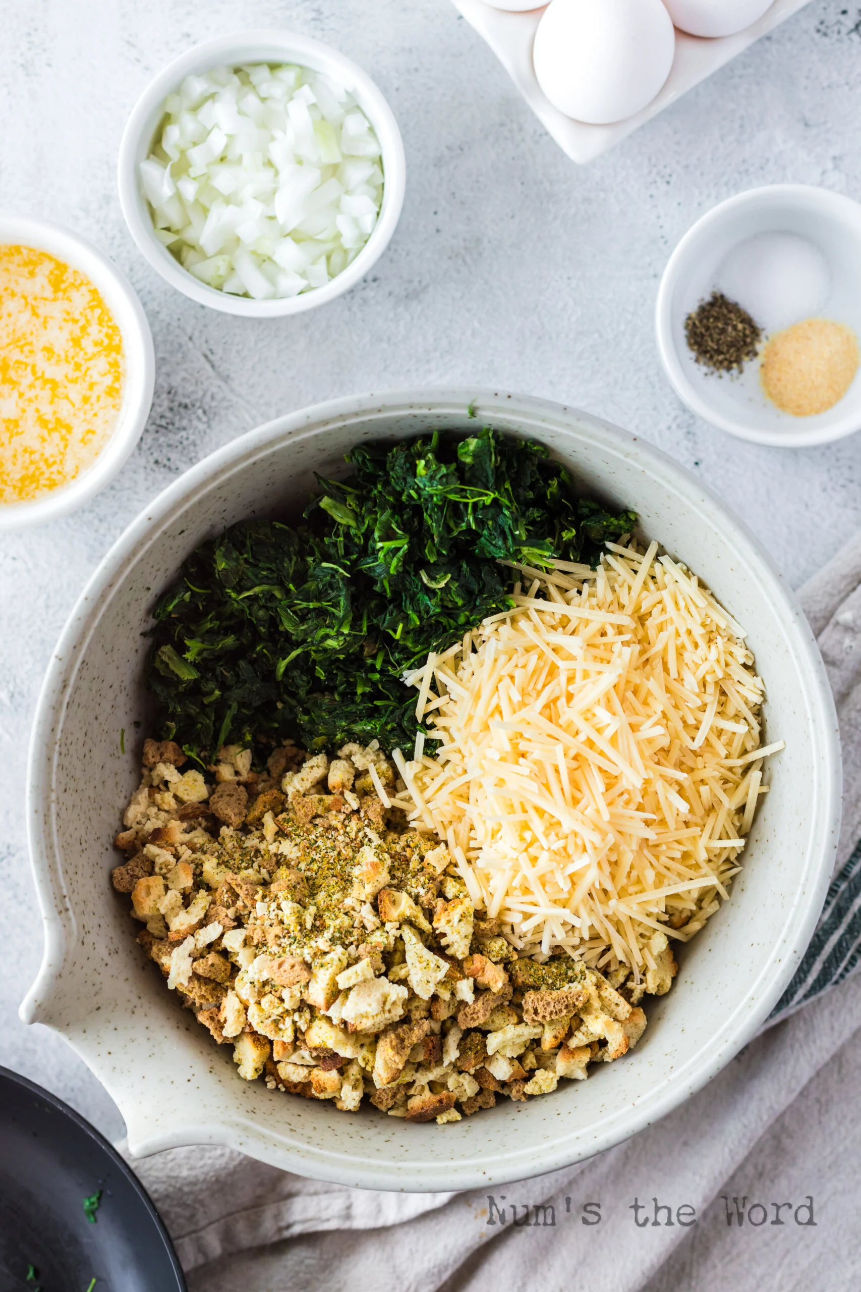 spinach, stuffing and parmesan cheese in a mixing bowl, unmixed.