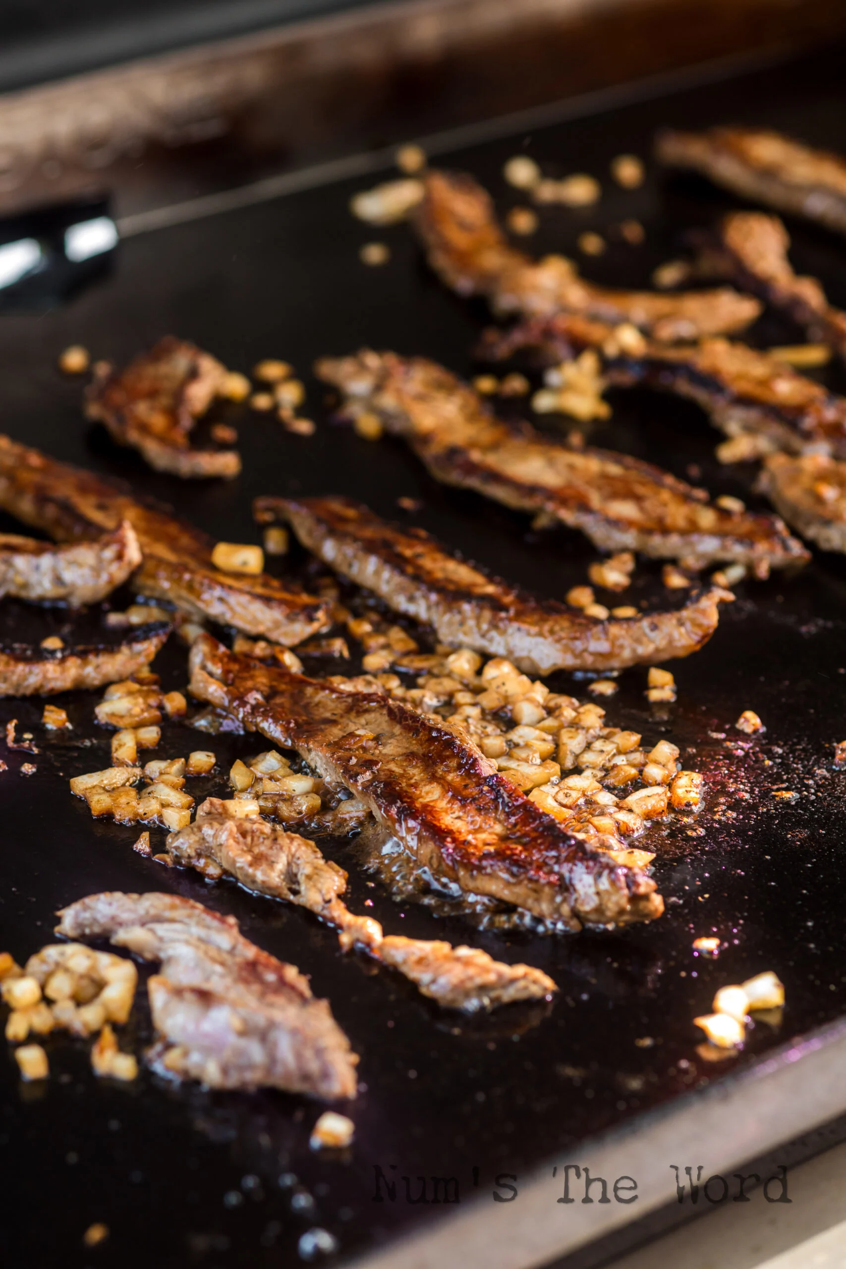 flank steak cooking on blackstone.