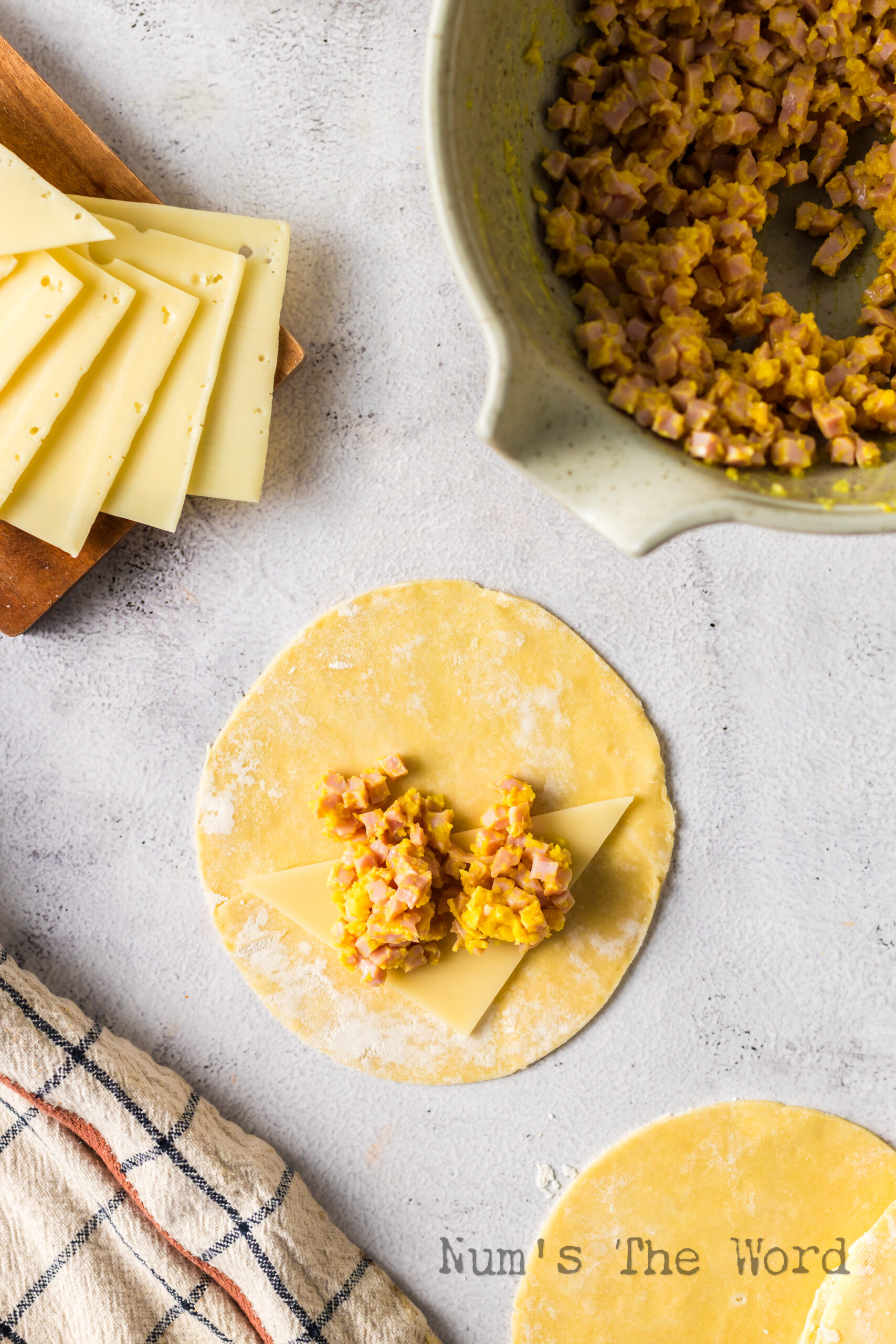 Cheese and filling laid out on an empanada disc.
