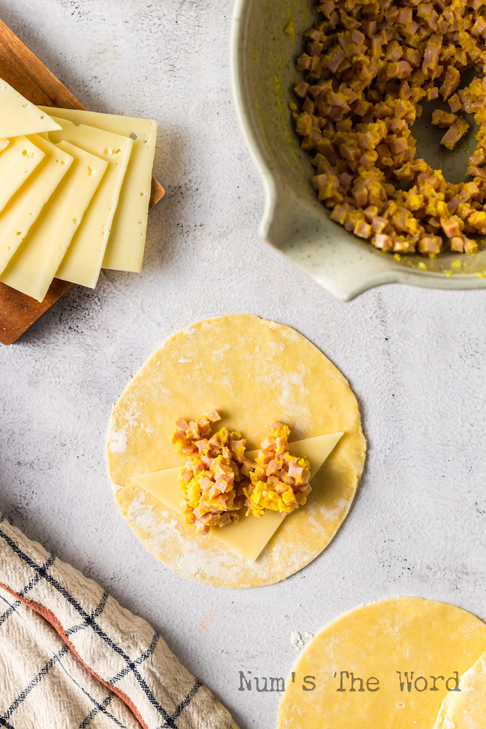 Cheese and filling laid out on an empanada disc.