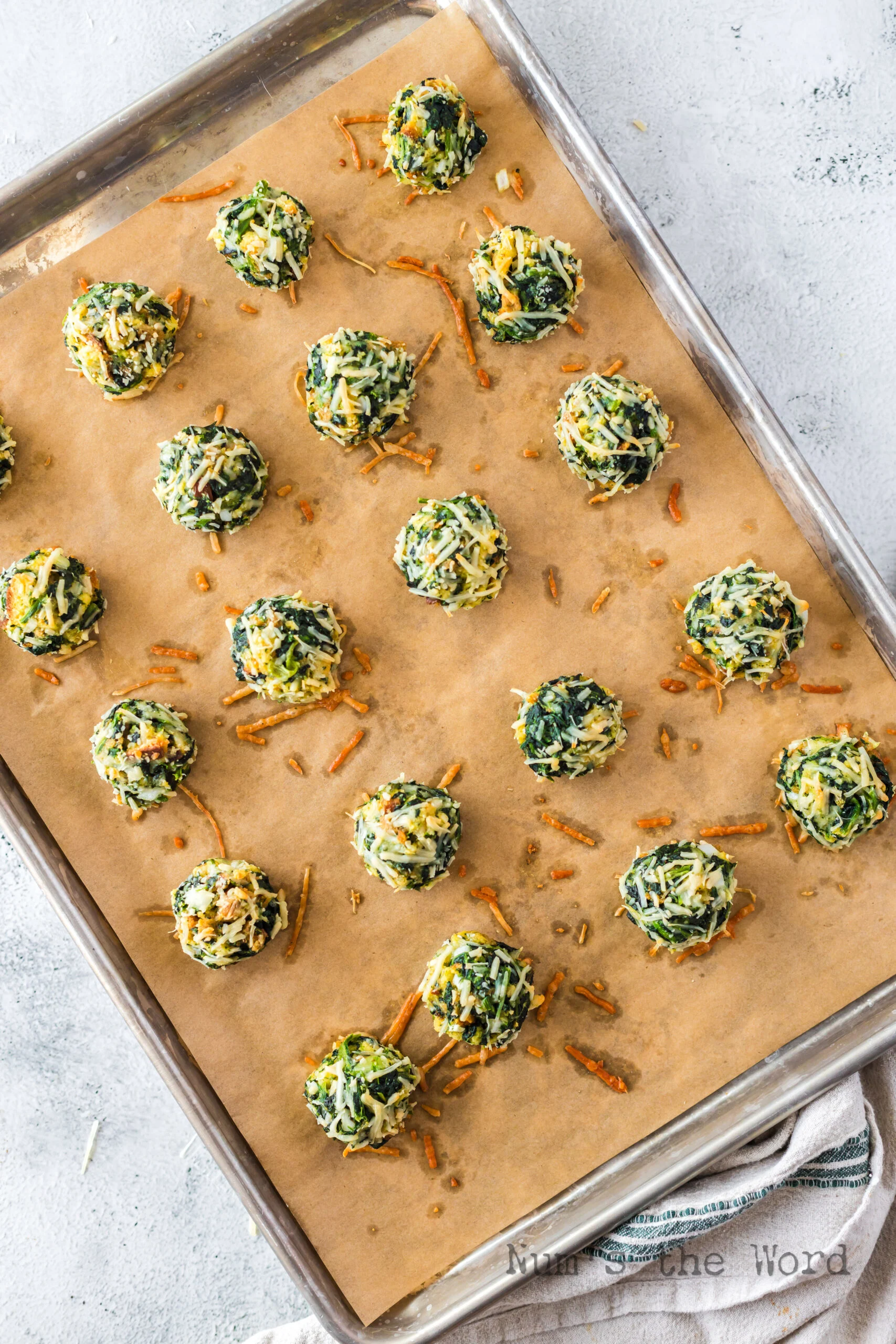 baked spinach balls laid out on baking sheet
