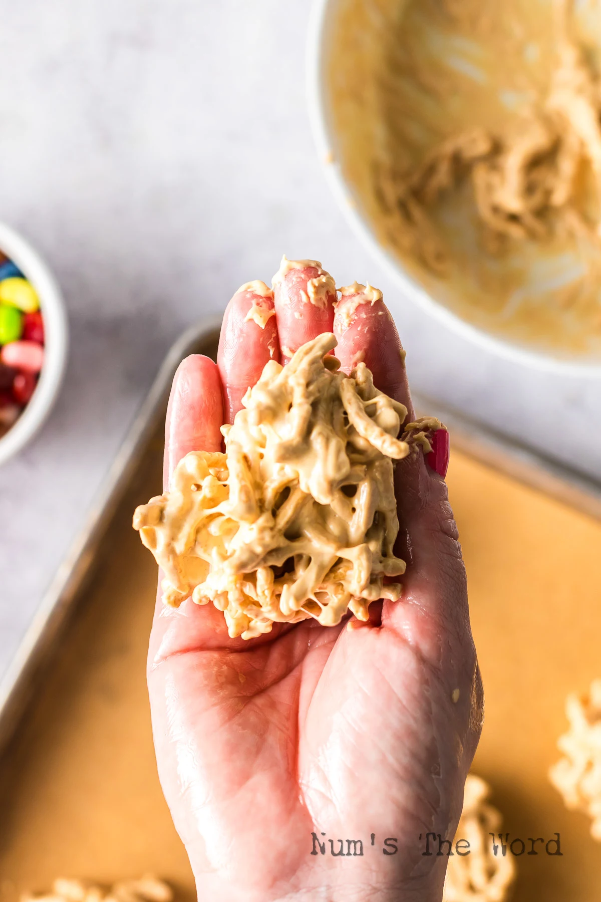 hand scooping a portion of treats to shape and mold into a nest.