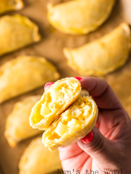 a cooked empanada cut in half to show filling.