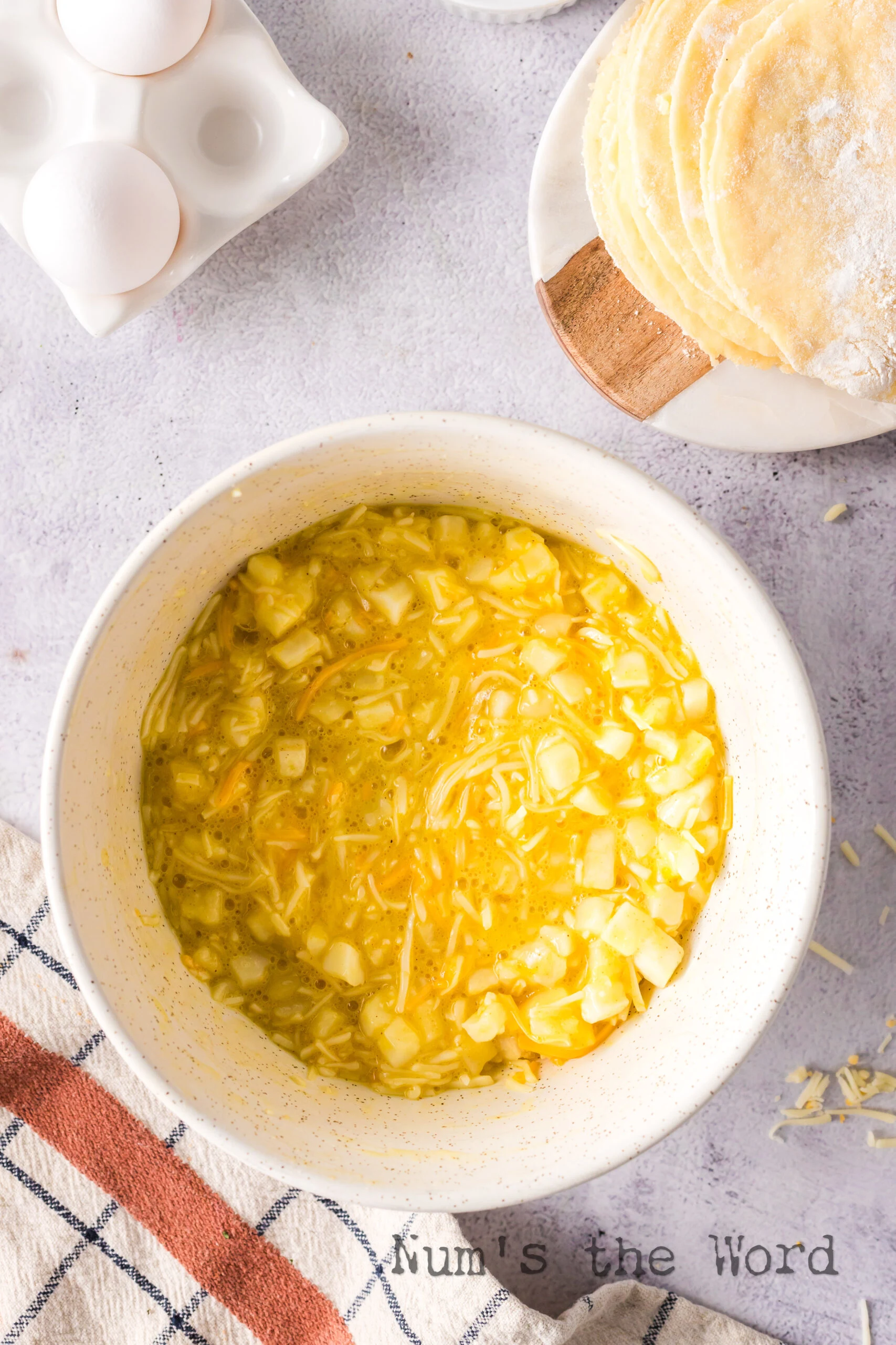 hash browns, eggs and cheese mixed up in a bowl.
