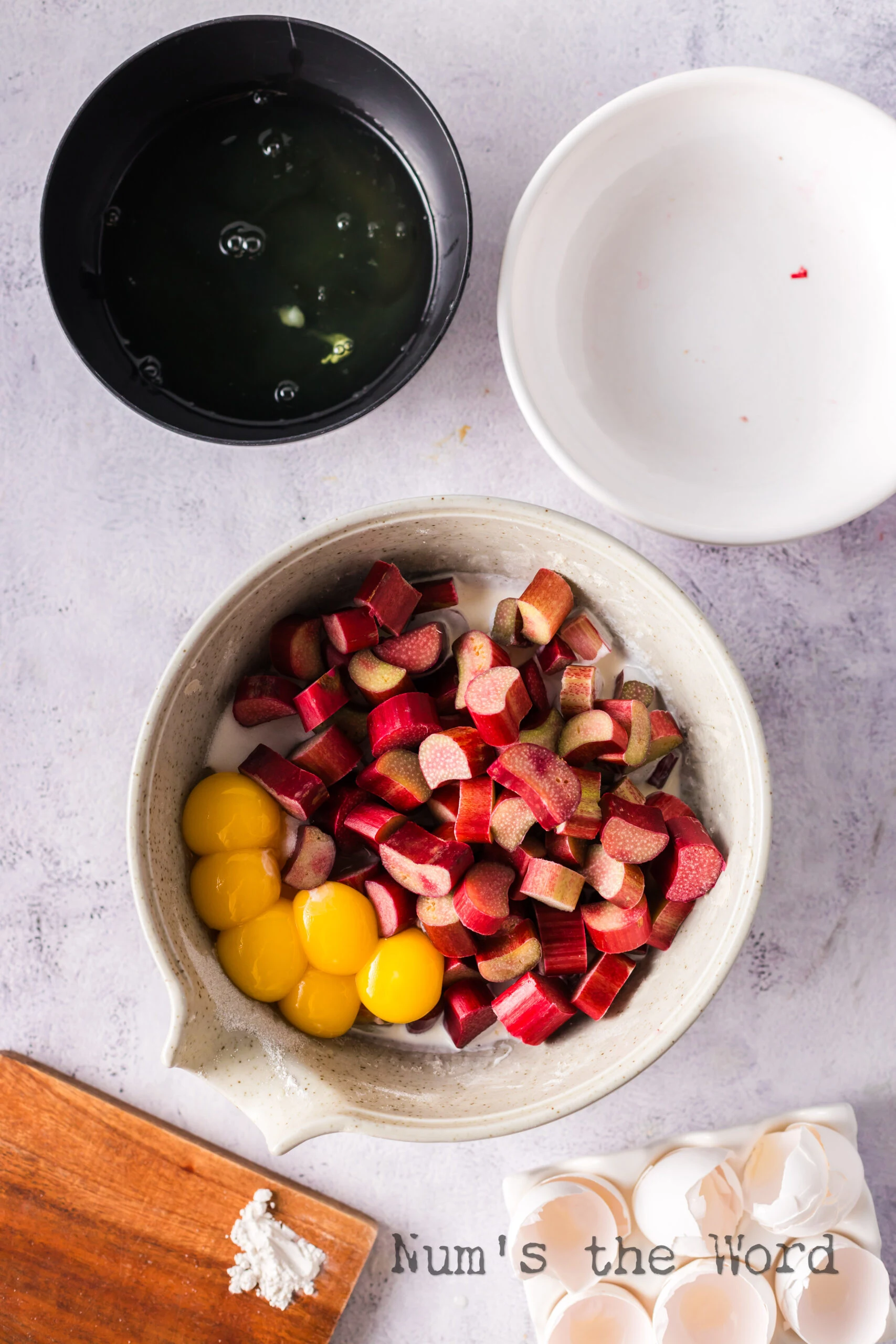 egg yolks, sugar, flour, heavy whipping cream, salt and rhubarb in a bowl, unmixed.