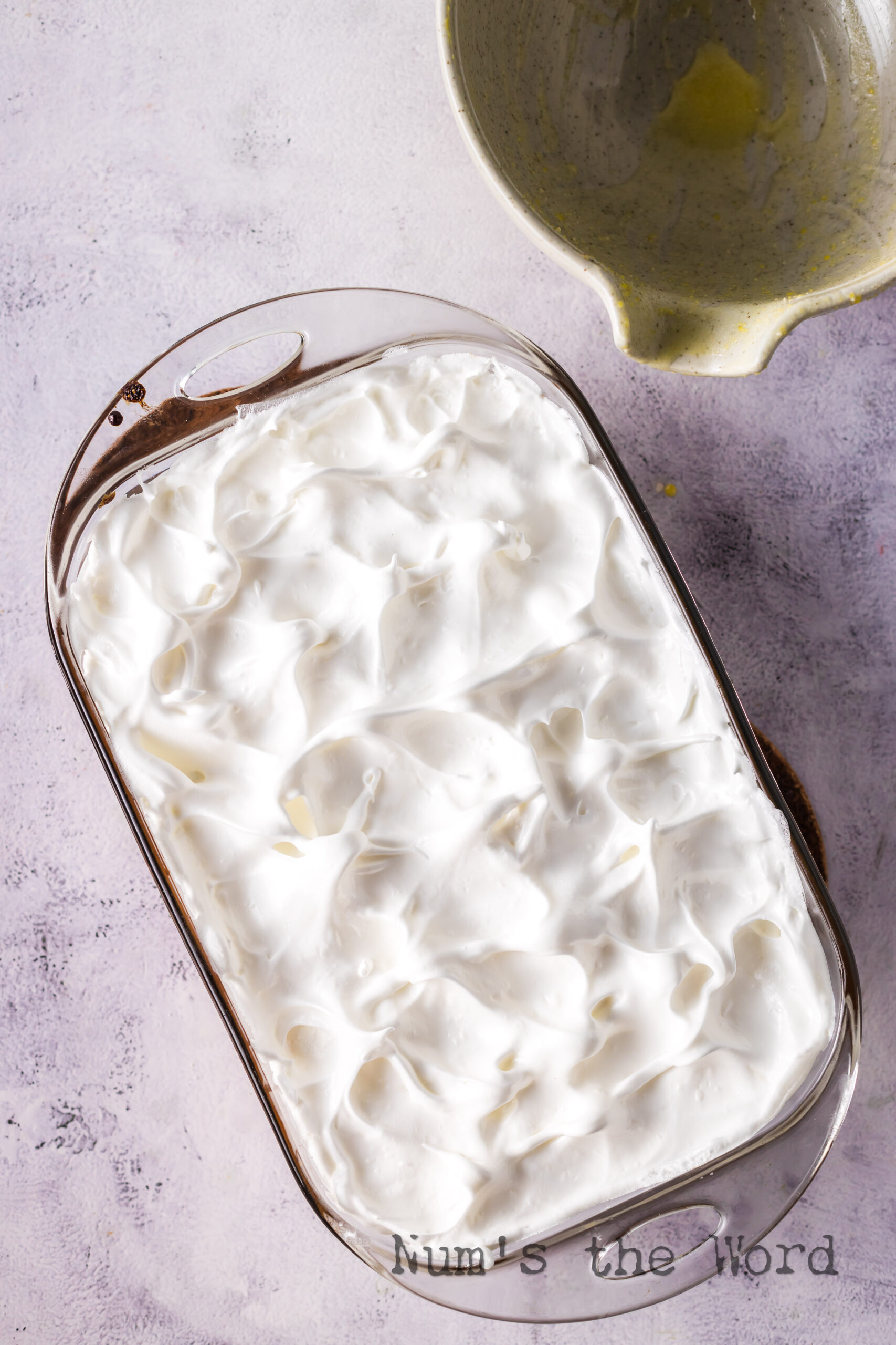 Meringue spread over rhubarb mixture with peeks.