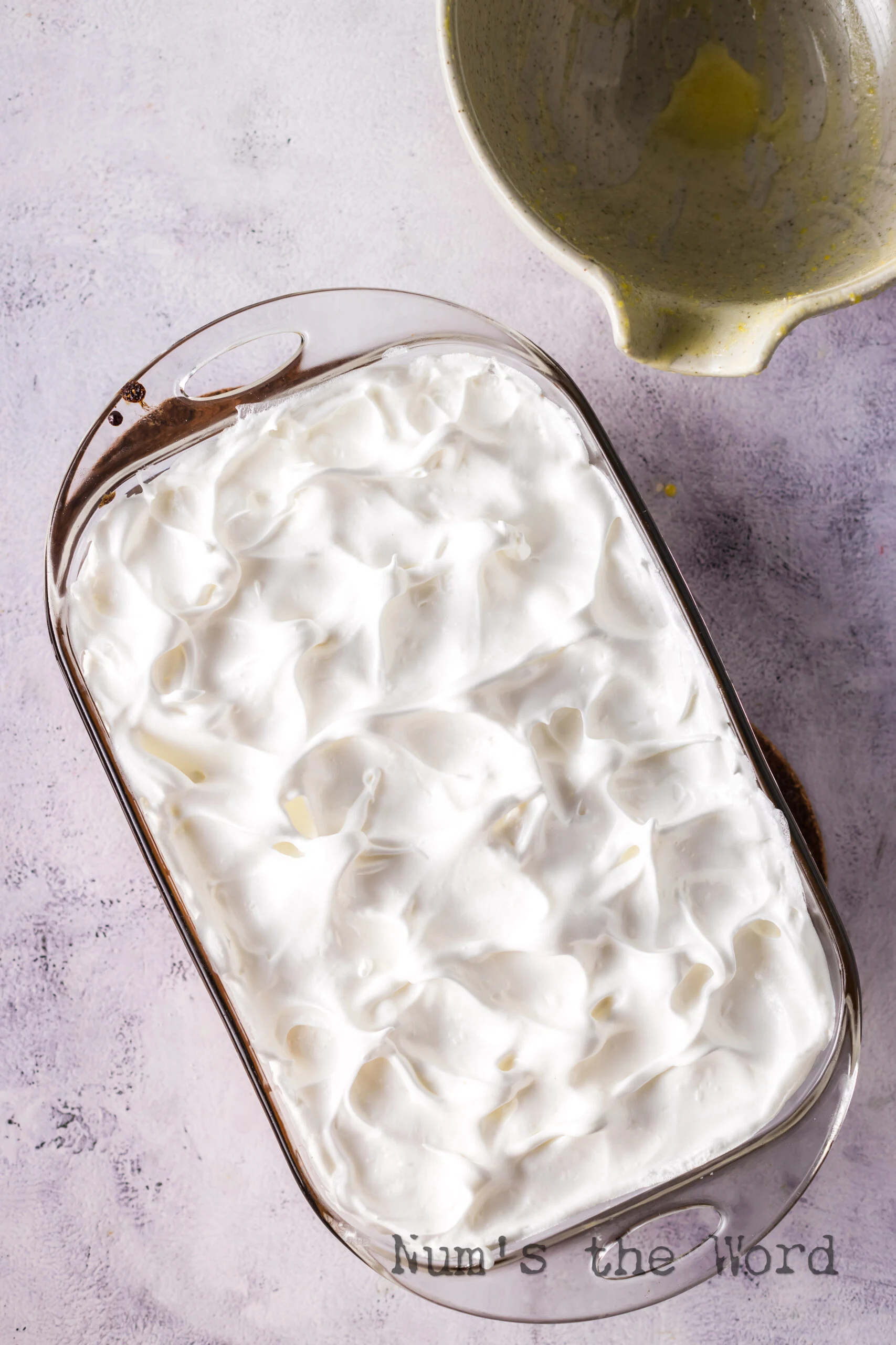 Meringue spread over rhubarb mixture with peeks.