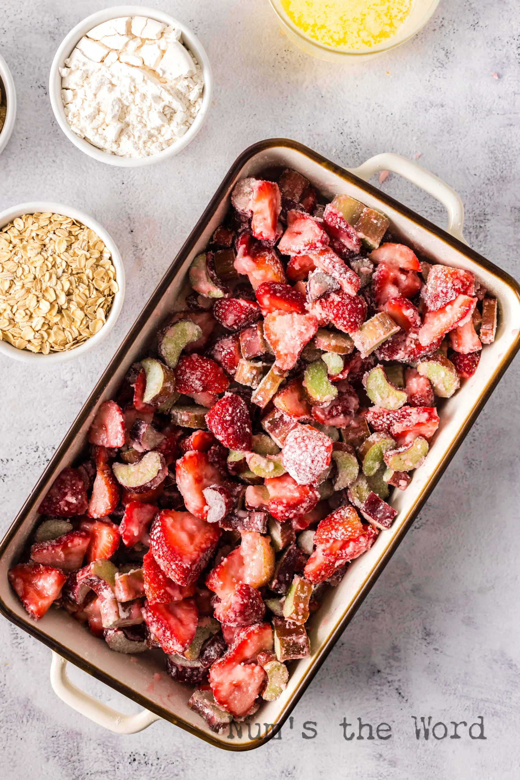 strawberry rhubarb mixture stirred in a casserole dish.