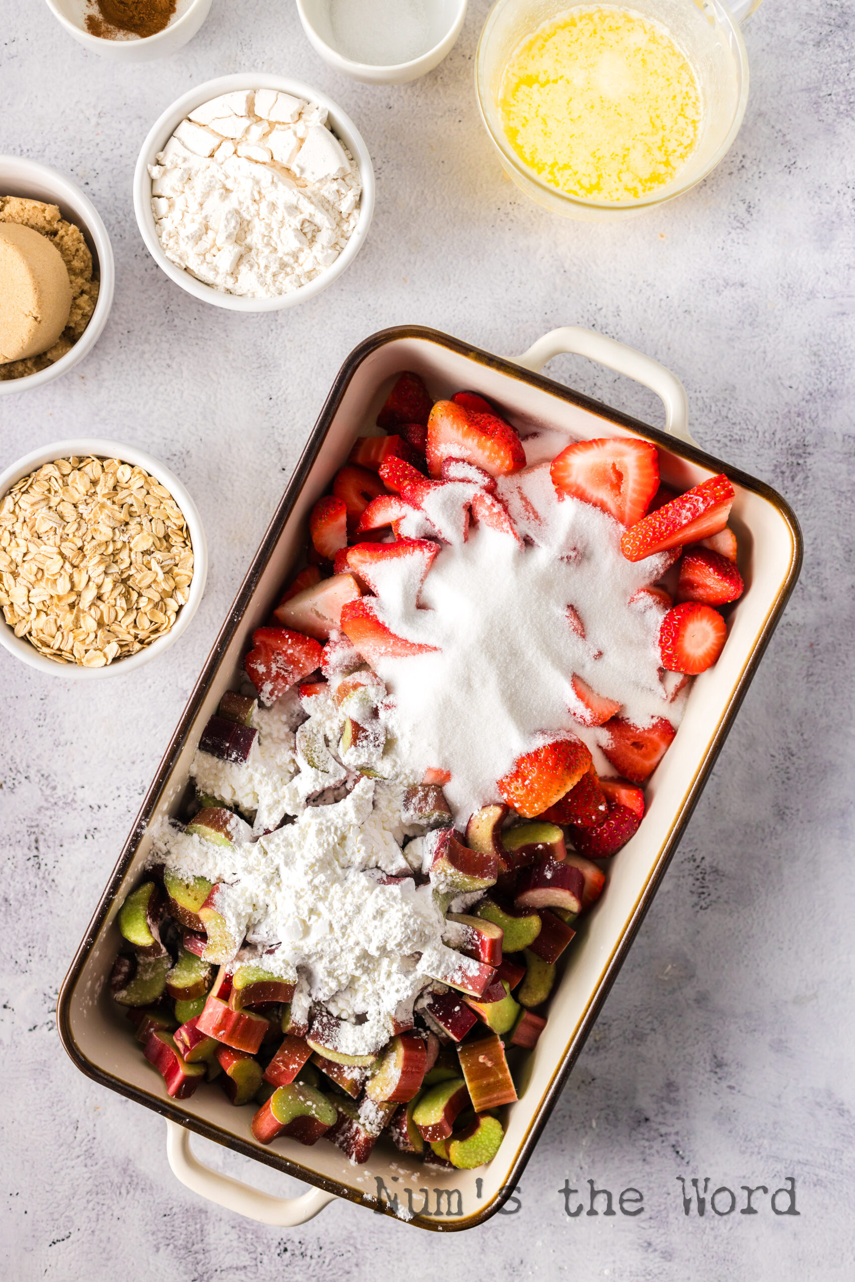 strawberries, rhubarb, white sugar, corn starch added in a casserole dish.