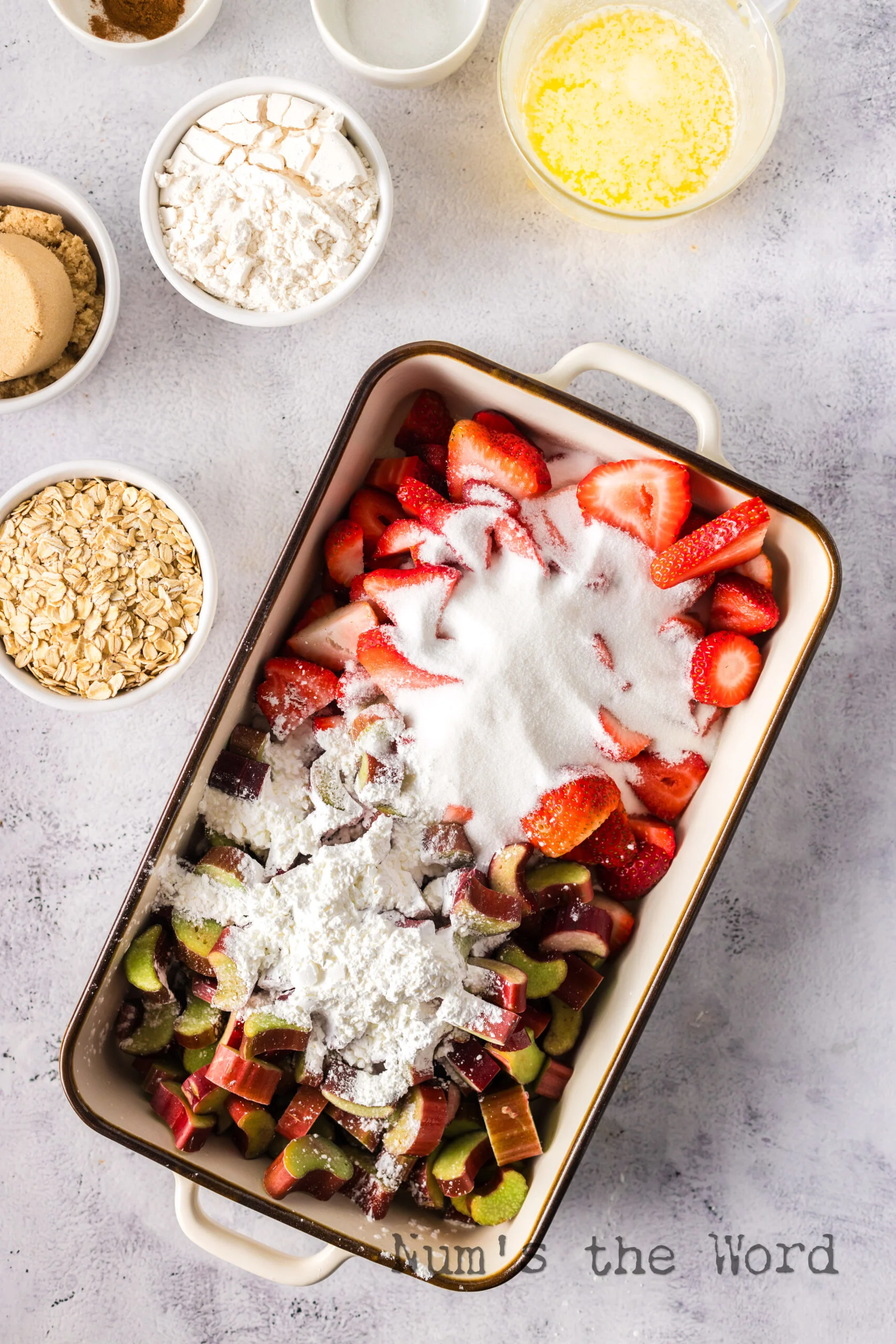 strawberries, rhubarb, white sugar, corn starch added in a casserole dish.