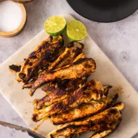grilled chicken with lime slices on a platter ready to serve.