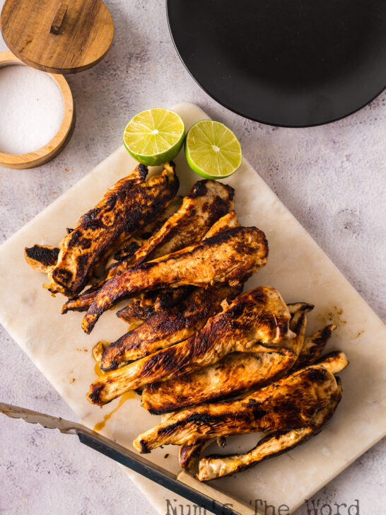 grilled chicken with lime slices on a platter ready to serve.