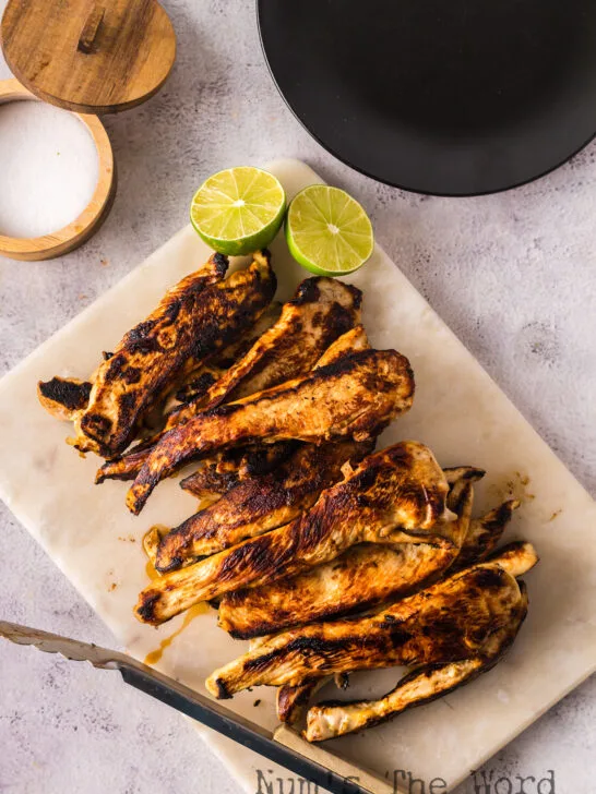 grilled chicken with lime slices on a platter ready to serve.
