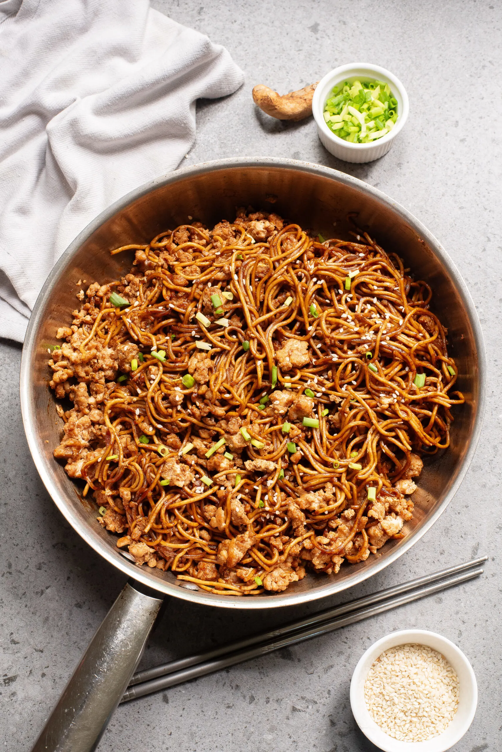 zoomed out image of chicken and noodles in skillet.