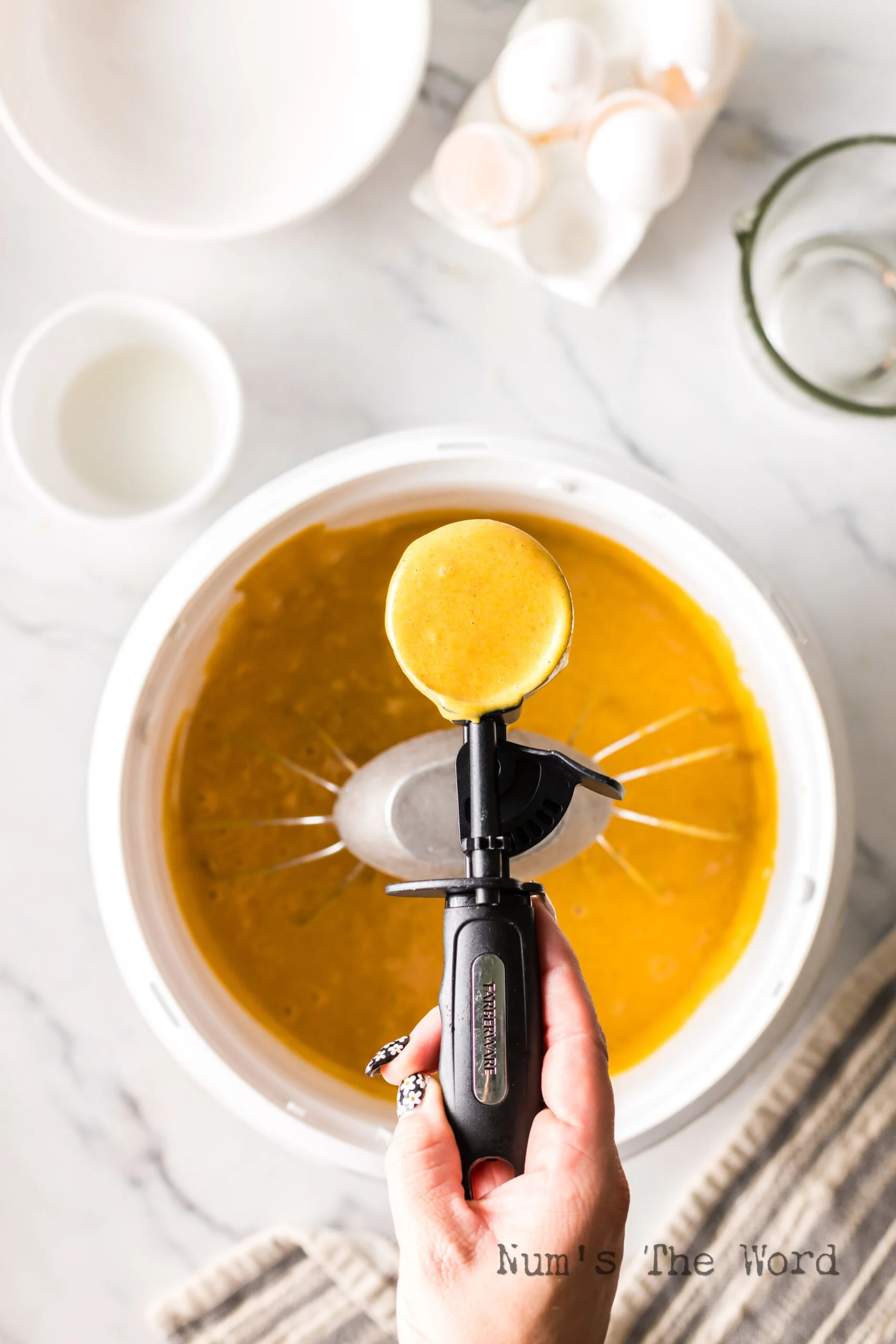 Batter in mixing bowl with a muffin scoop full