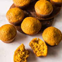 top view looking down at muffins on the counter. One muffin cut in half to show how yummy they are.