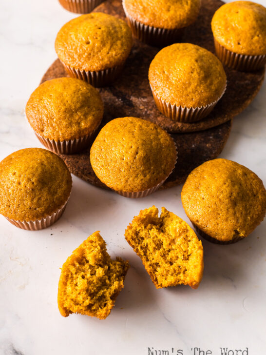 top view looking down at muffins on the counter. One muffin cut in half to show how yummy they are.