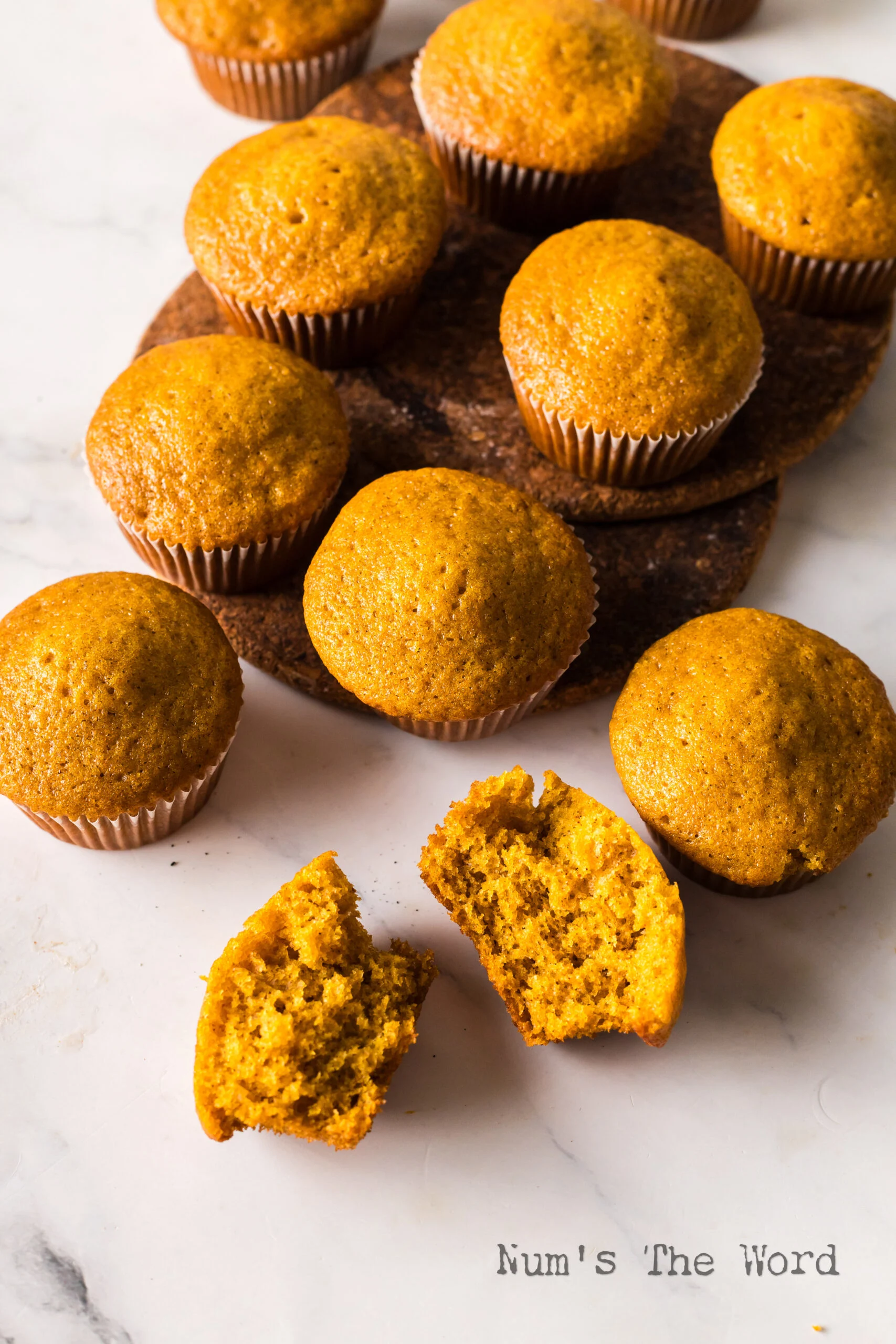 top view looking down at muffins on the counter. One muffin cut in half to show how yummy they are.