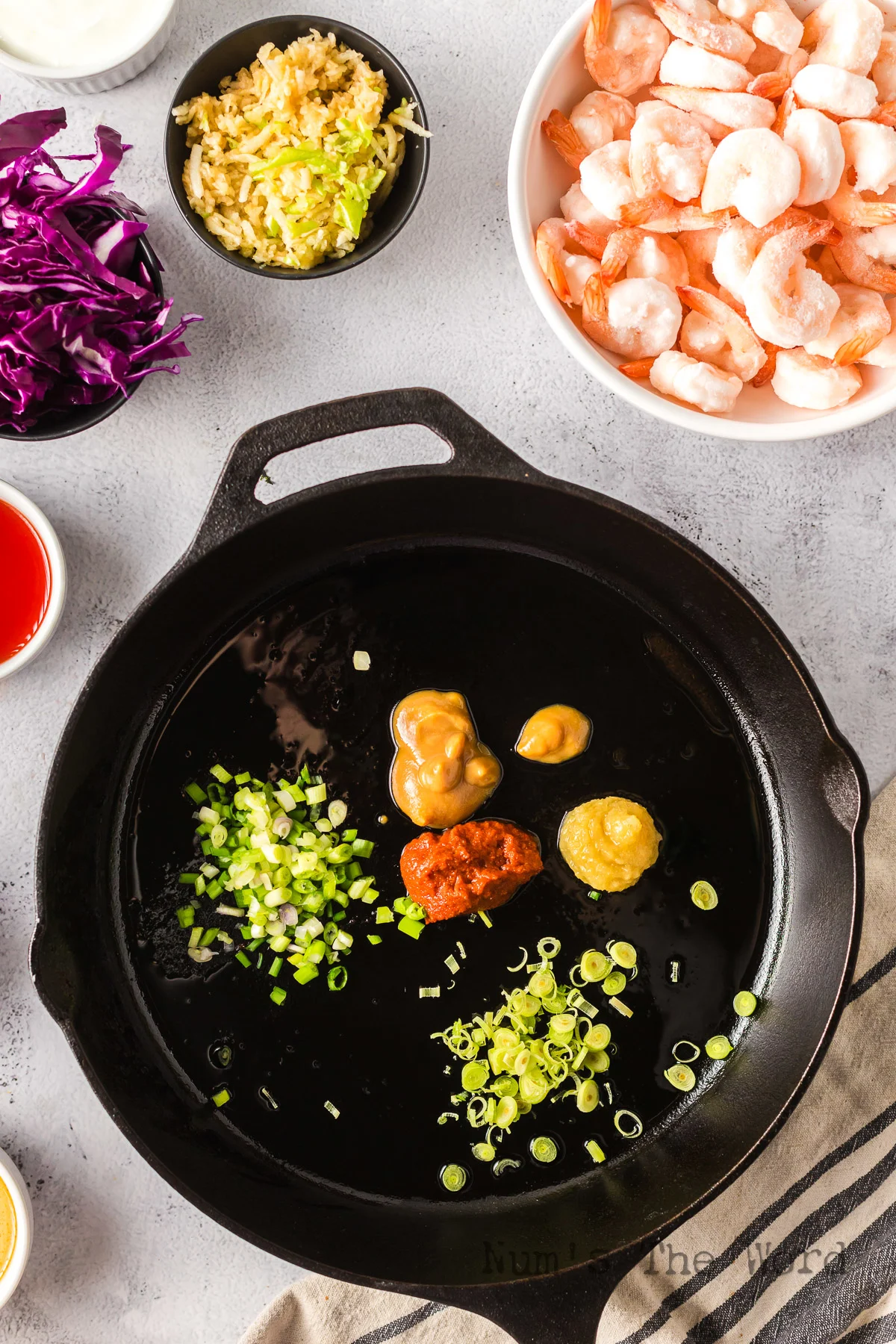 oil, red curry paste, miso paste, scallion, lemongrass and ginger added to skillet.