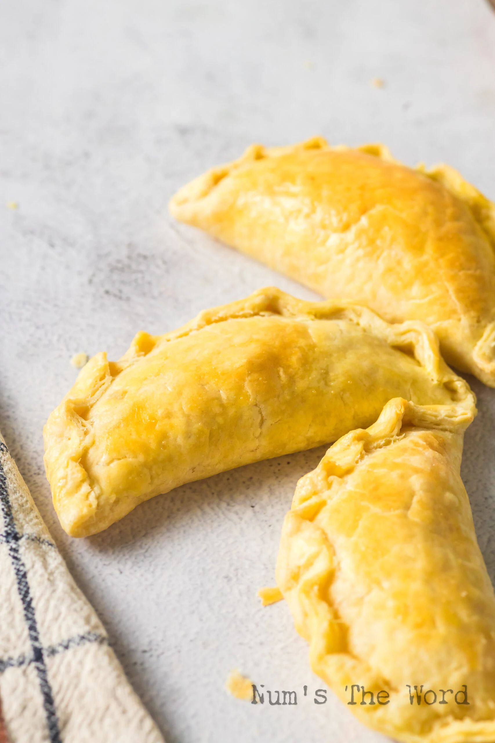 3 baked empanadas laid out on the counter.