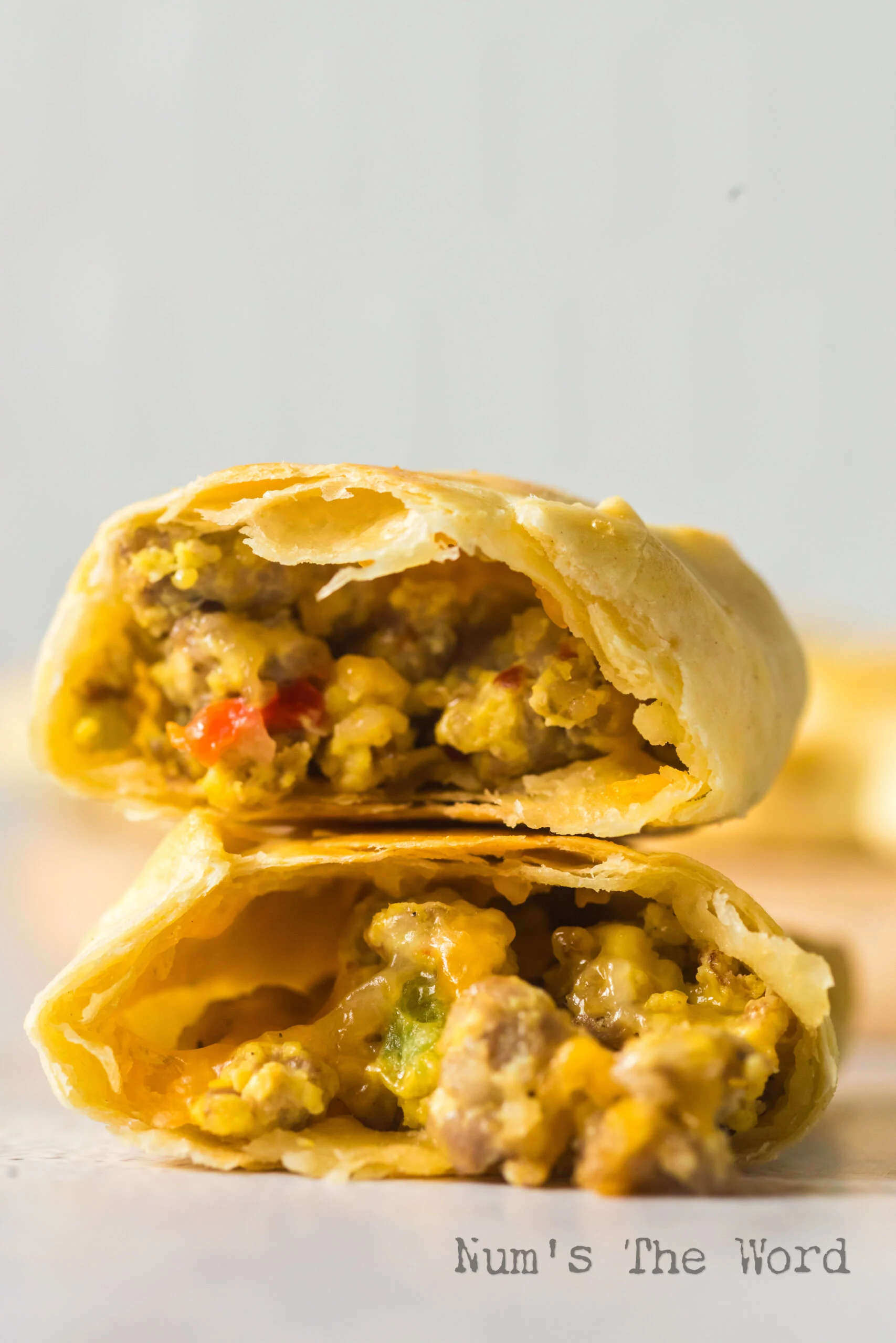 Baked empanada cut in half to show sausage and egg filling.