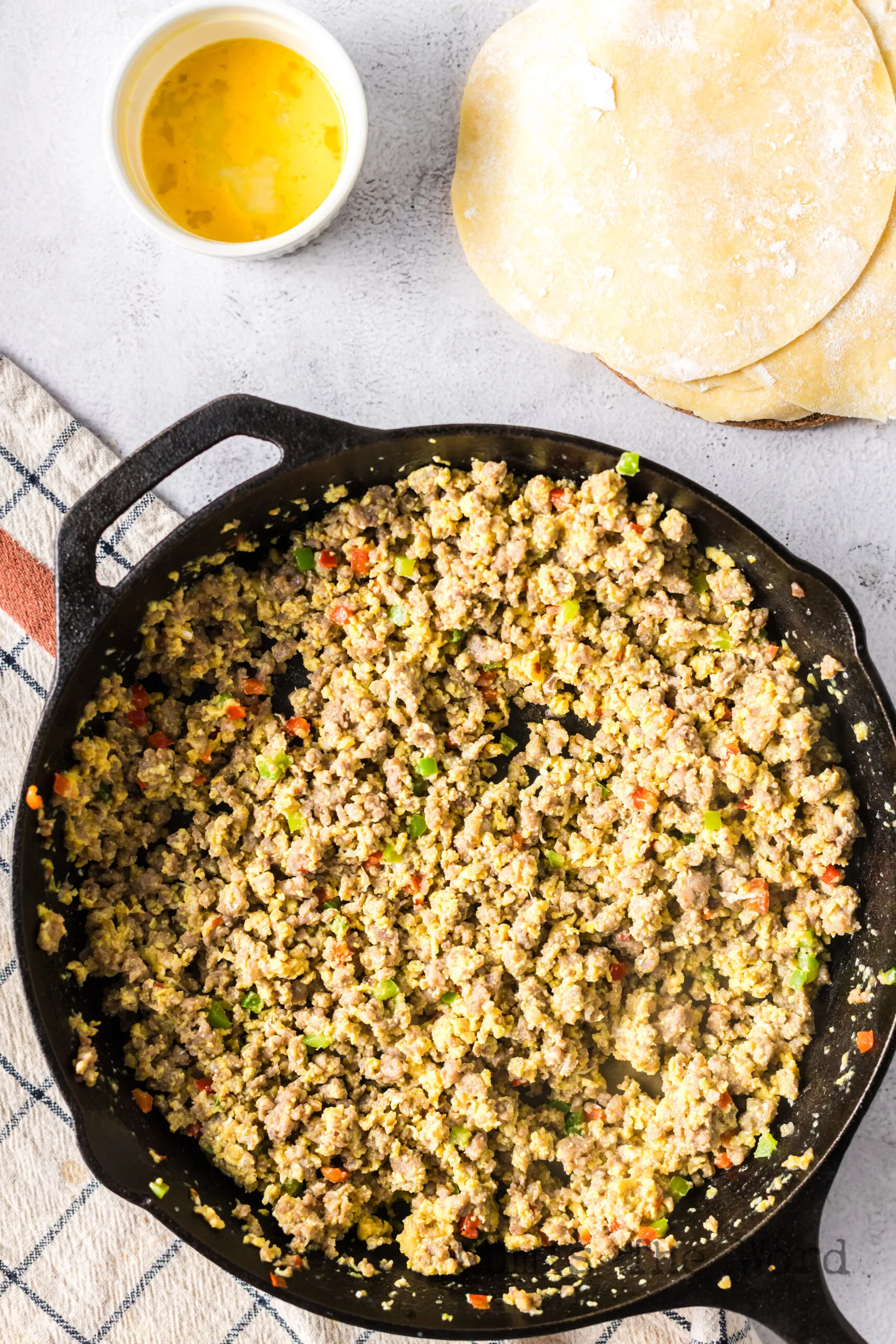 cooked eggs and sausage in skillet.