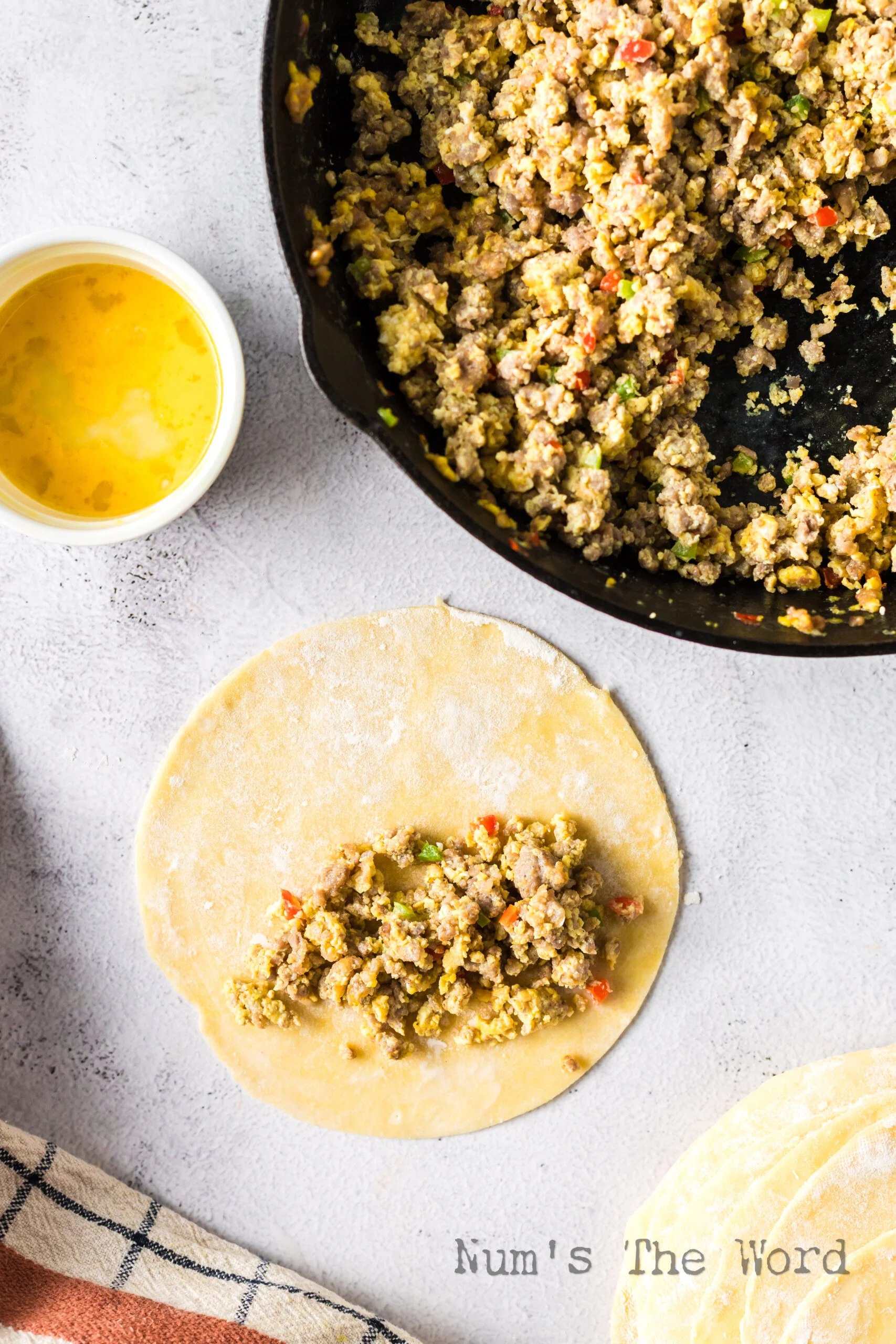 empanada dough disc with a pile of a sausage and egg mixture.