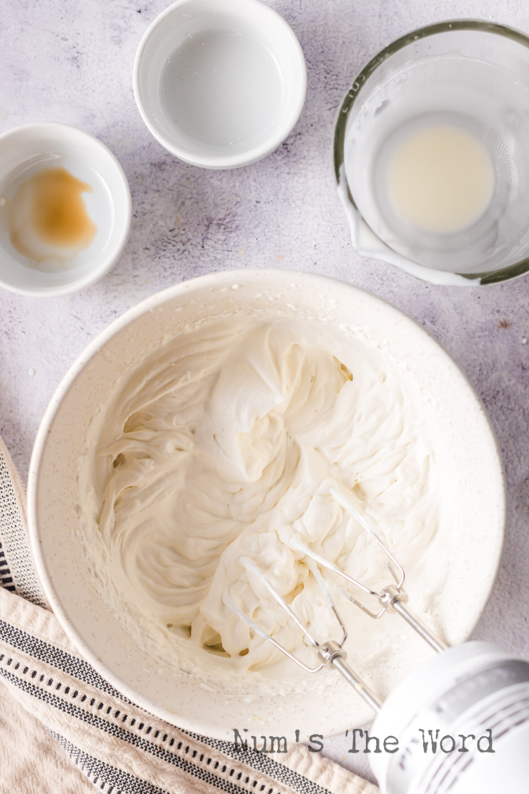 camera view looking down at whipped cream in a bowl, mixed.