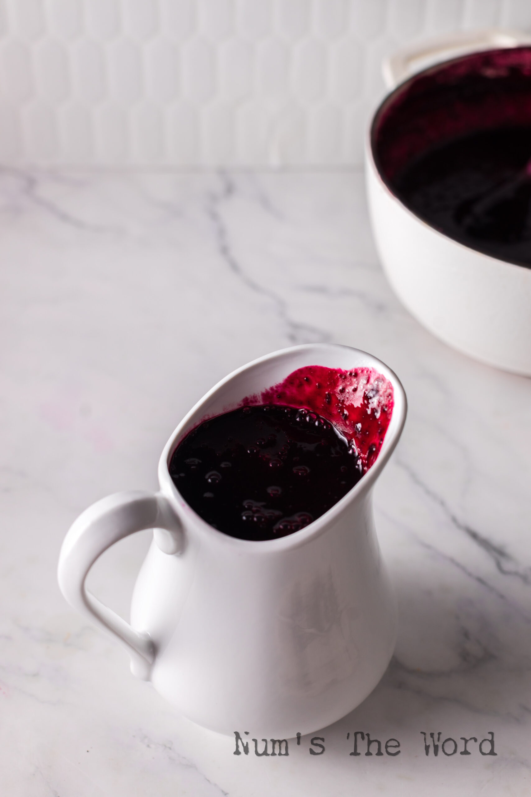 A gravy boat full of blueberry syrup