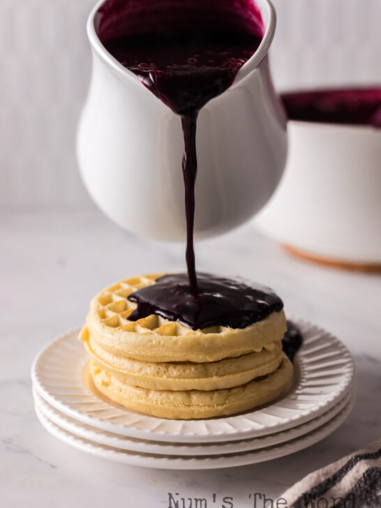 Syrup being poured onto waffles.