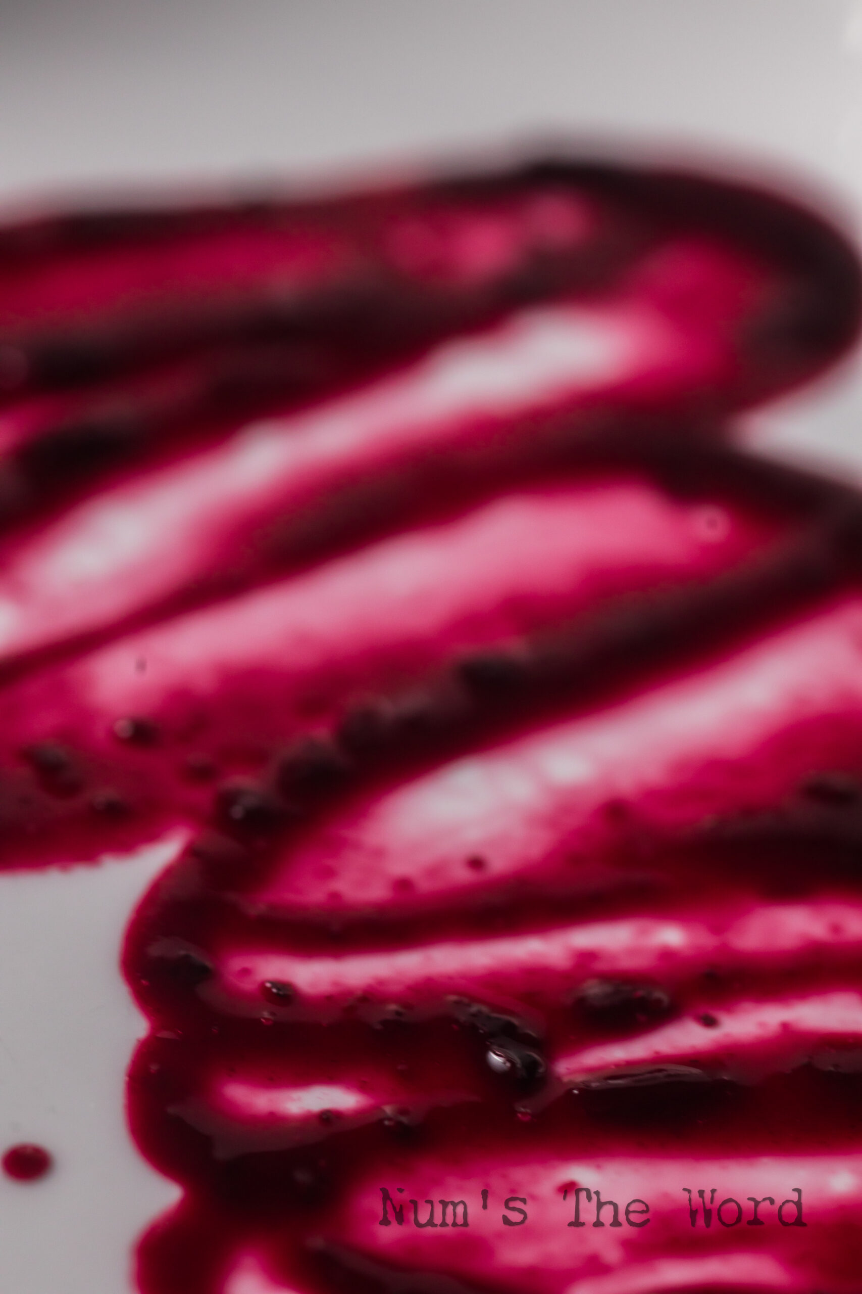 Blueberry syrup smeared on a plate to show how thick it is.