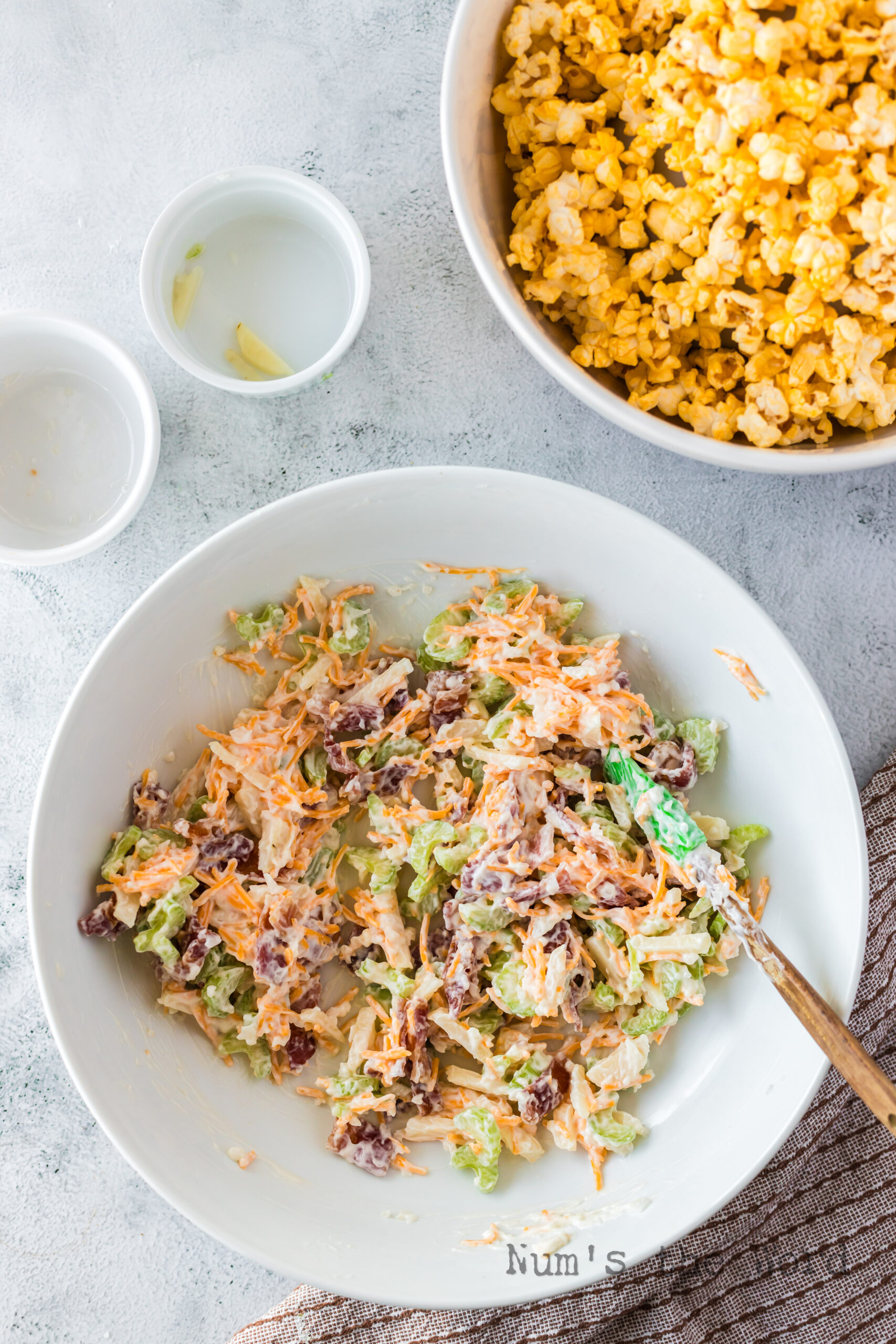 all salad ingredients except with popcorn being mixed in a bowl.